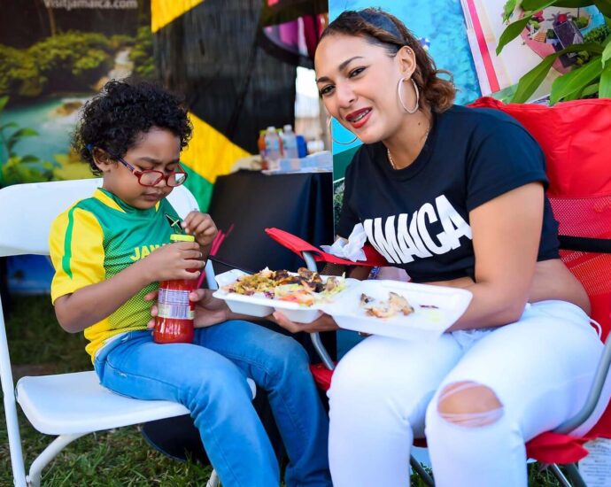 Woman sitting with boy with Jamaica shirts on