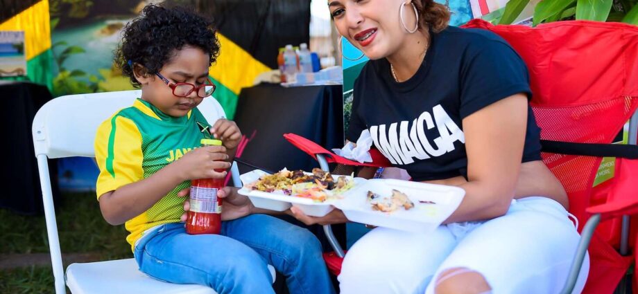 Woman sitting with boy with Jamaica shirts on